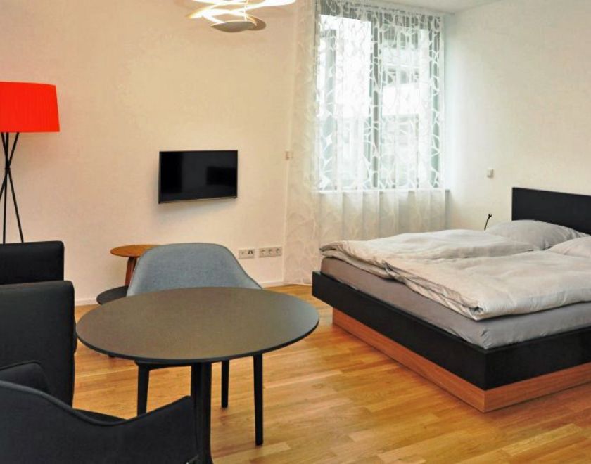 Gästeappartement mit Bett, Sitzgelegenheit und TV
